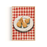 A framed illustration of three pears on a white plate, set against a red and white checkered tablecloth.