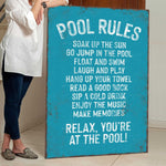 a woman standing next to a pool rules sign