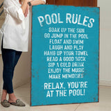 a woman standing next to a pool rules sign