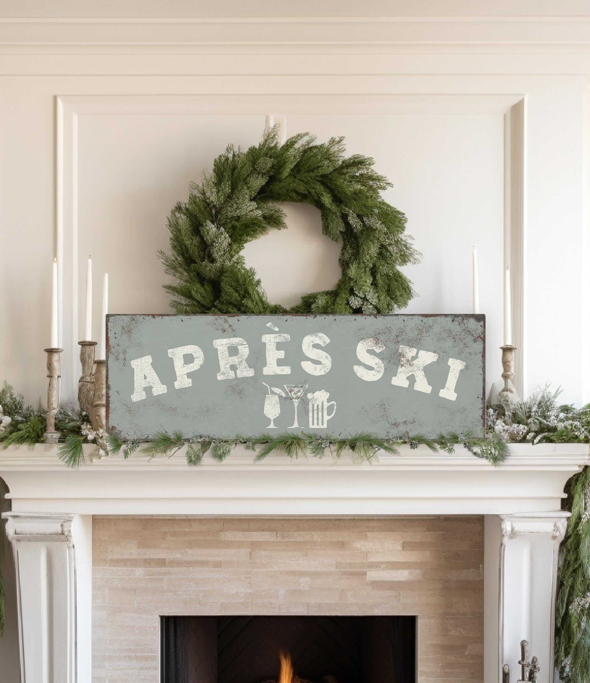 a fireplace mantel decorated with a wreath, candles, and a sign that reads "APRÈS SKI".