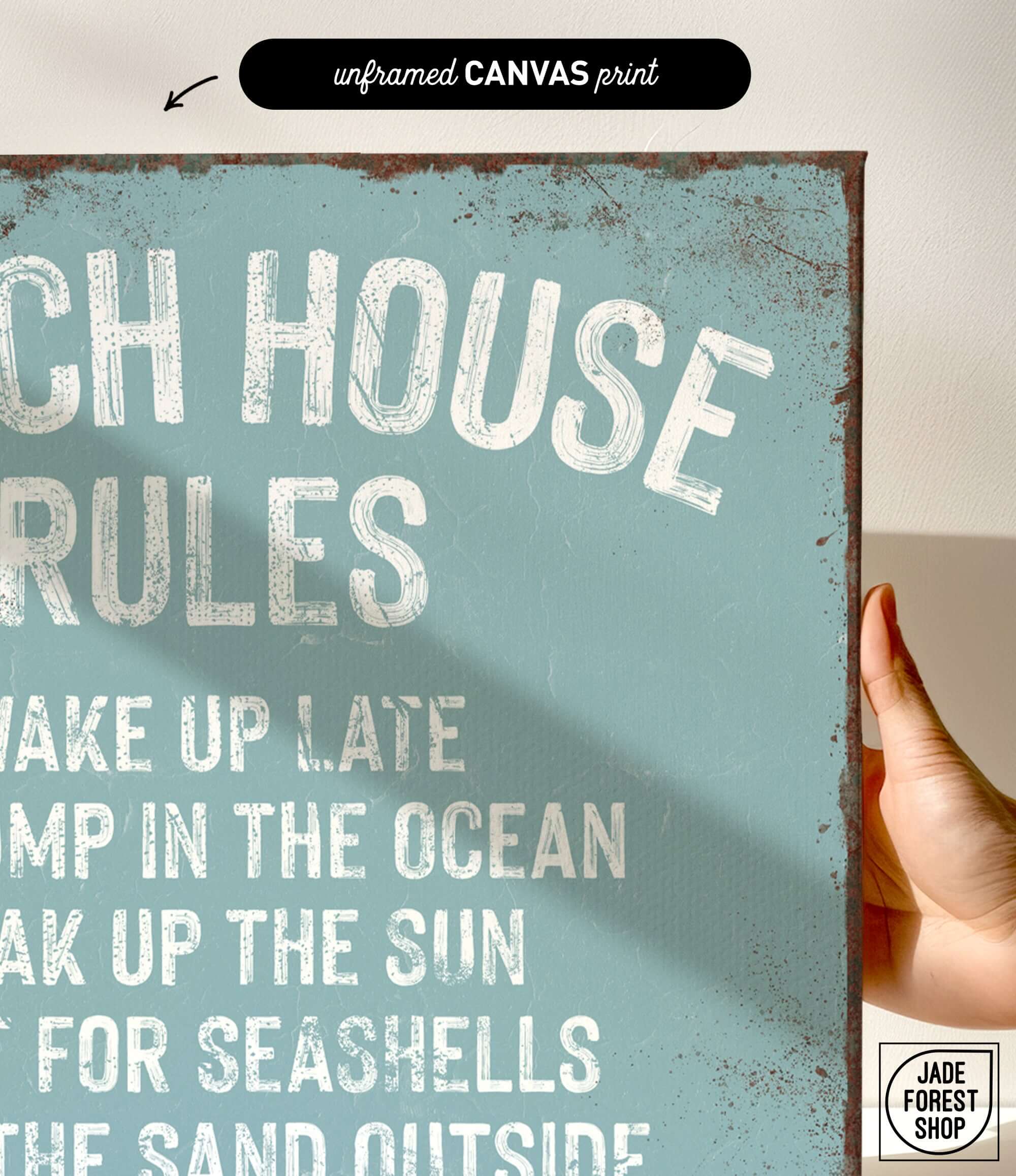 a hand holding a sign that says beach house rules