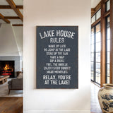 a sign that reads "Lake House Rules" hanging on a wall in a room with a fireplace and a vase.