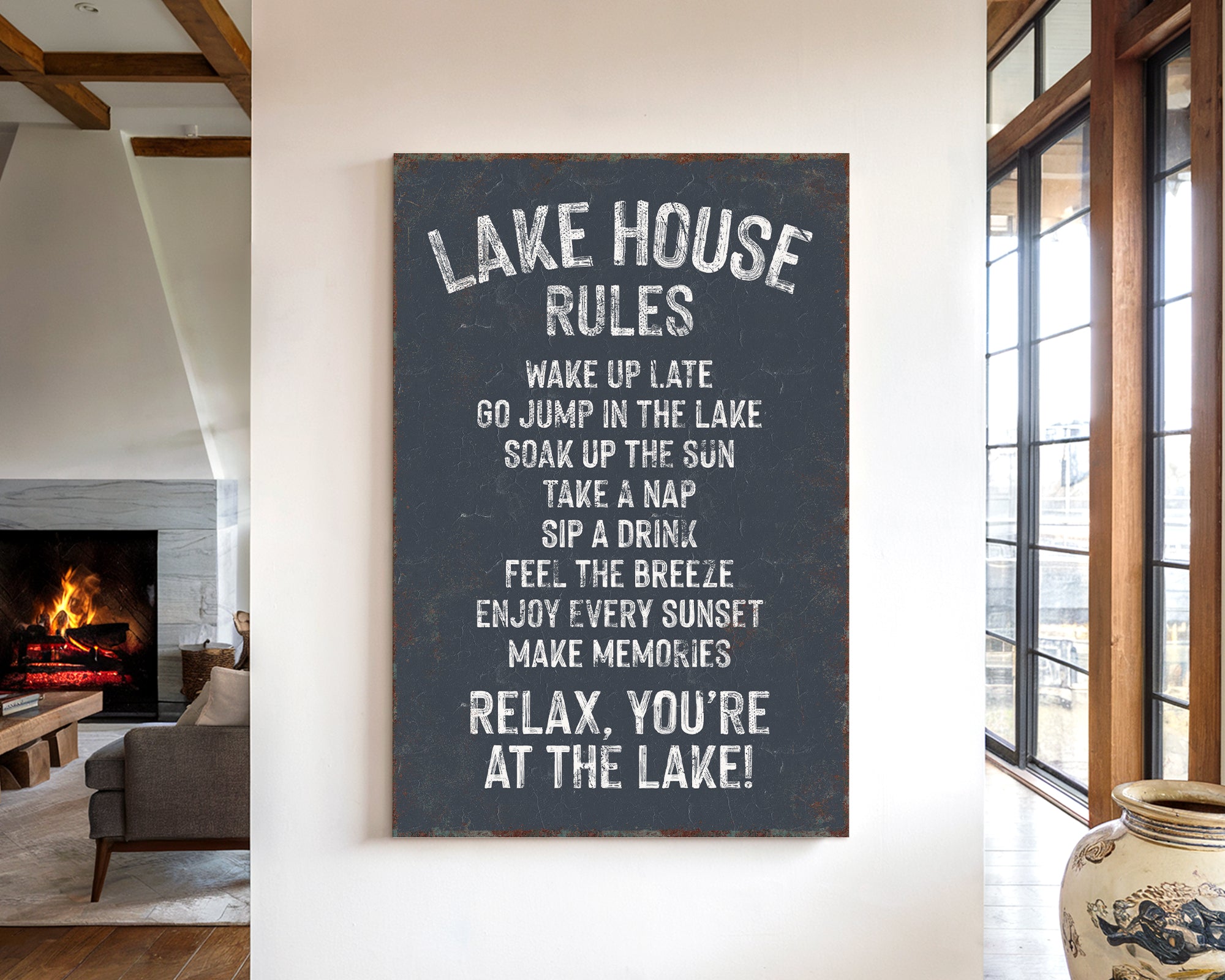 a sign that reads "Lake House Rules" hanging on a wall in a room with a fireplace and a vase.
