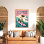 a framed poster of a woman surfing with the text "BEACH HAIR DON'T CARE" on it, hanging on a wall above a brown leather couch with striped pillows.