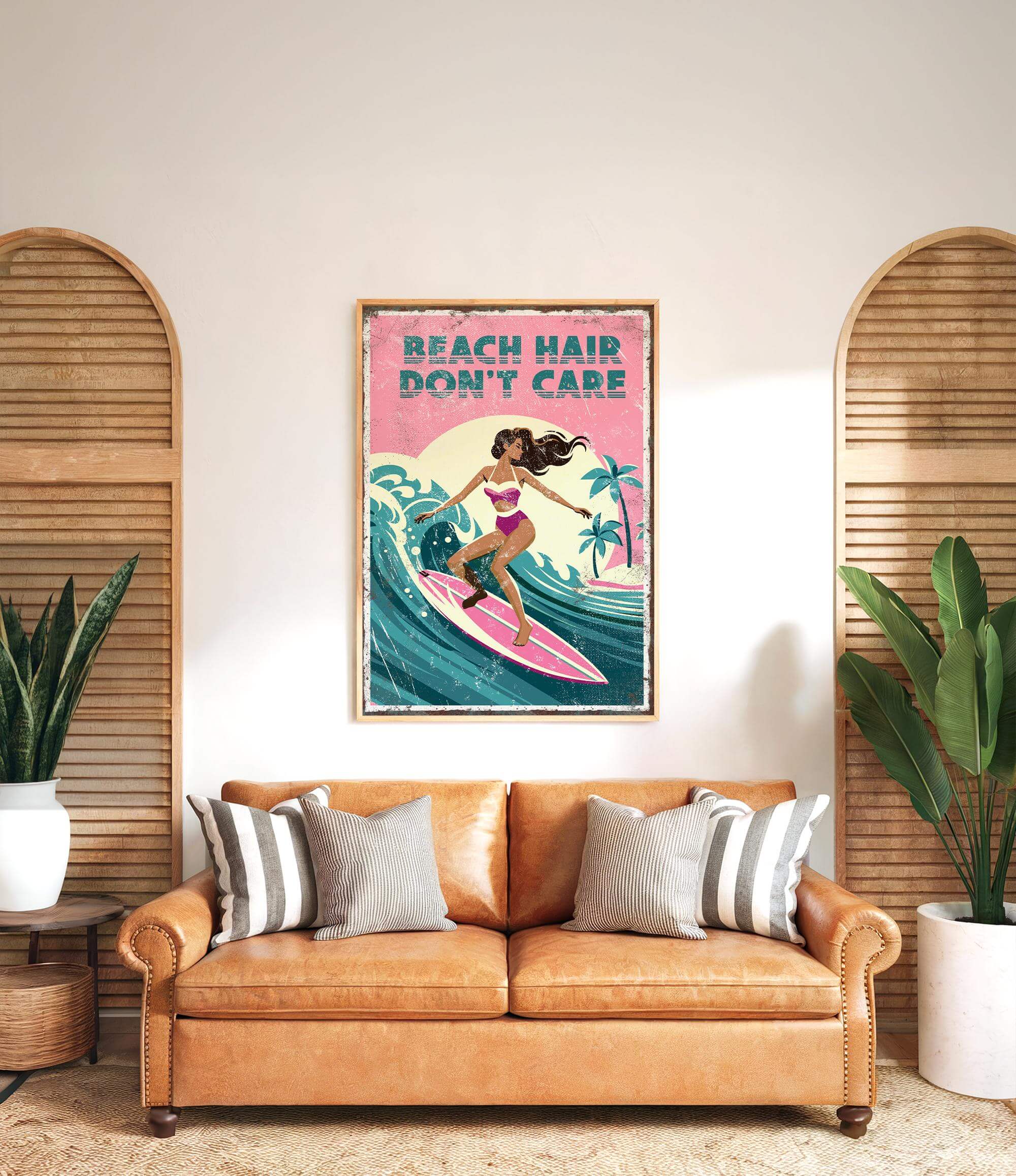 a framed poster of a woman surfing with the text "BEACH HAIR DON'T CARE" on it, hanging on a wall above a brown leather couch with striped pillows.