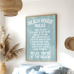 The Beach House Rules Sign, Painted Wood, Tide, hangs on the wall of a coastal-themed bedroom, adding charming beach house decor with its relaxed guidelines.