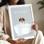 A woman is holding a framed picture with a dog sitting in a bathtub filled with bubbles, accompanied by the text "WASH YOUR PAWS".