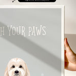 a hand holding a canvas print of a dog's face, with the text "Wash Your Paws" written on it.