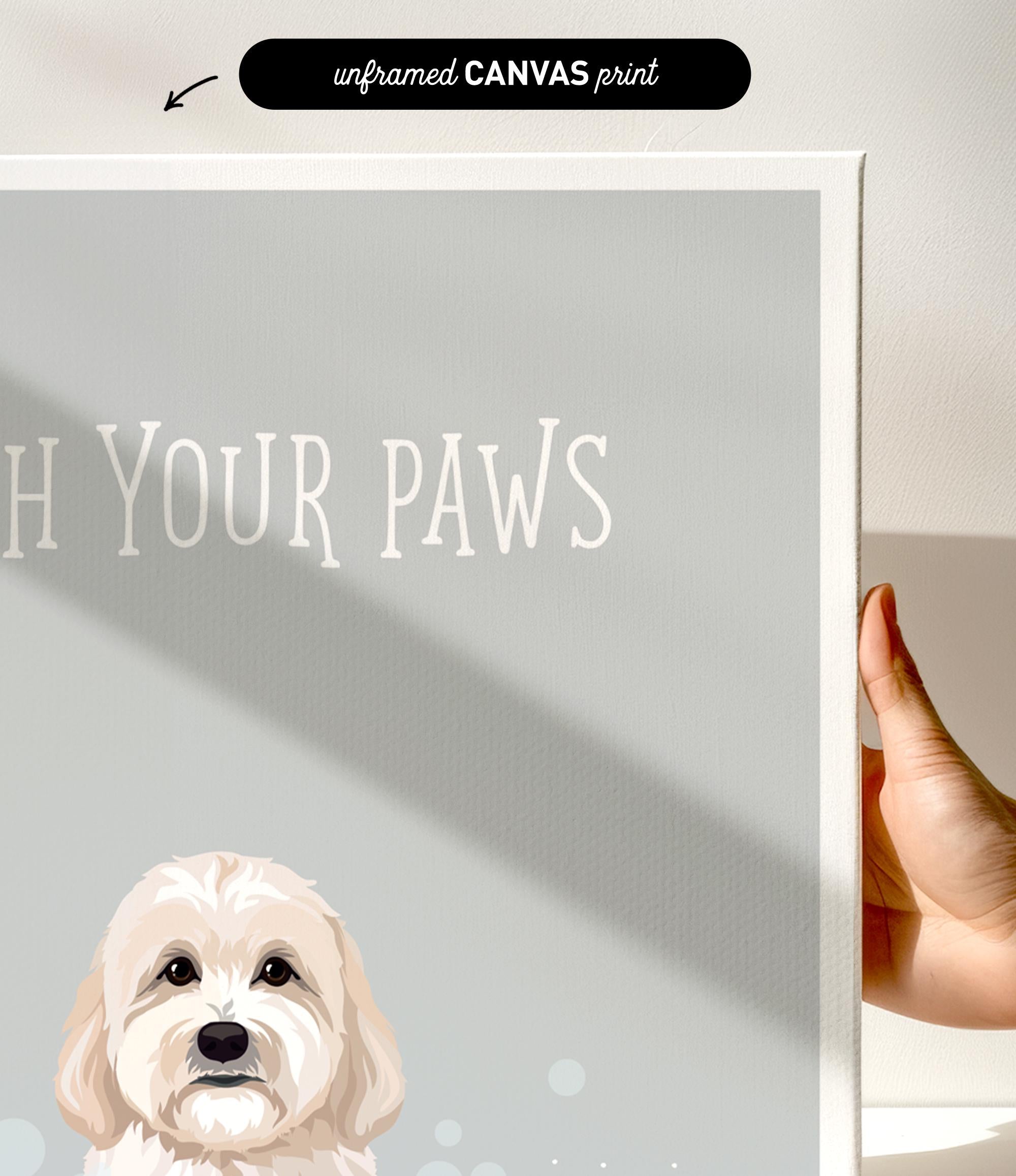 a hand holding a canvas print of a dog's face, with the text "Wash Your Paws" written on it.