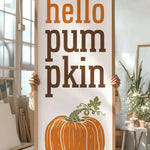 a person holding a sign that says hello pumpkin
