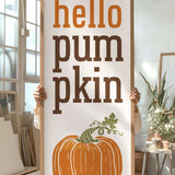 a person holding a sign that says hello pumpkin
