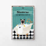 A vintage-style poster advertising Siamese Soap and Bubble Bath Co., featuring a Siamese cat sitting in a bathtub filled with bubbles.