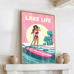 A framed poster of a woman paddleboarding on a lake, with the text "LAKELIFE" prominently displayed.