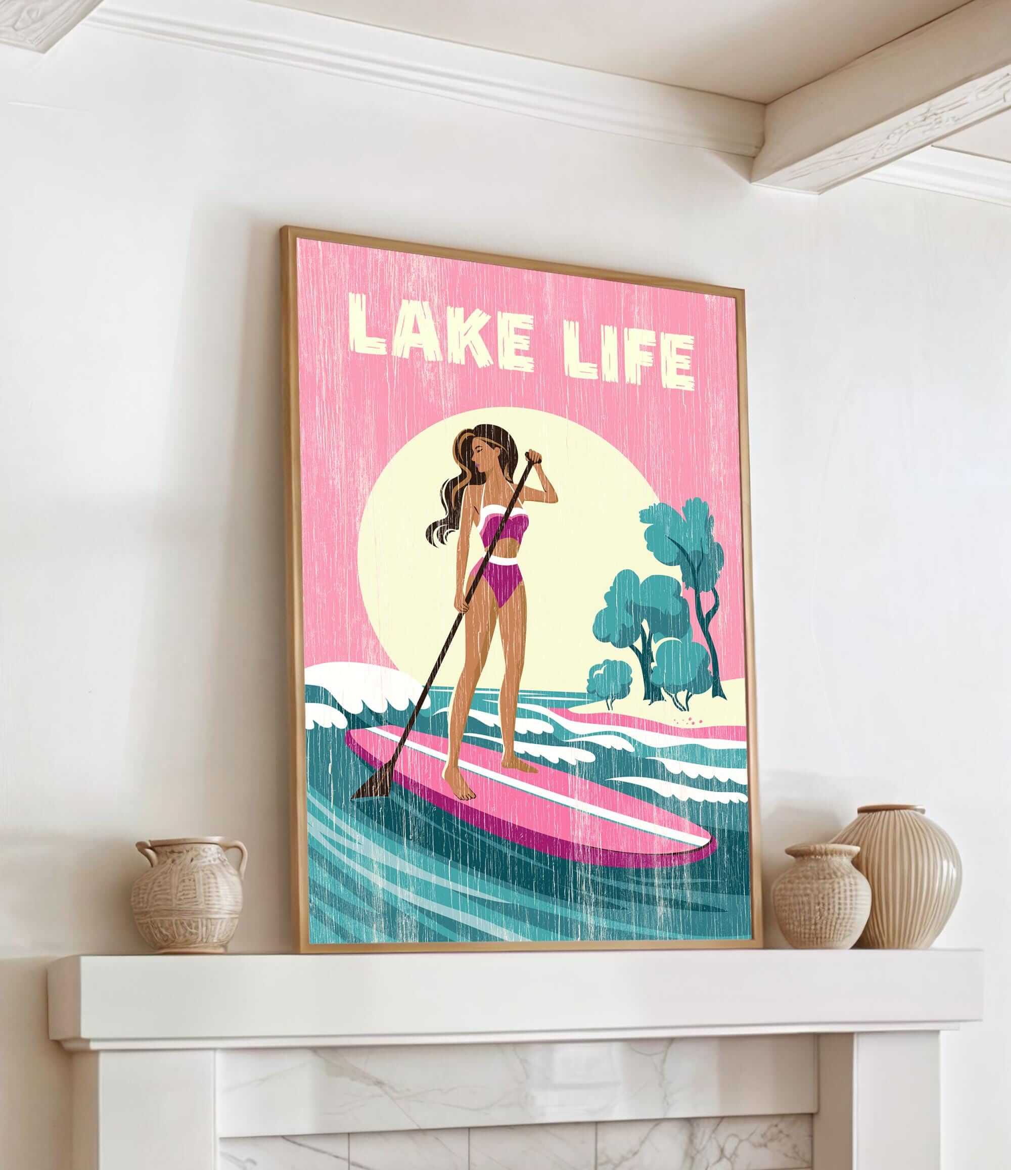 A framed poster of a woman paddleboarding on a lake, with the text "LAKELIFE" prominently displayed.