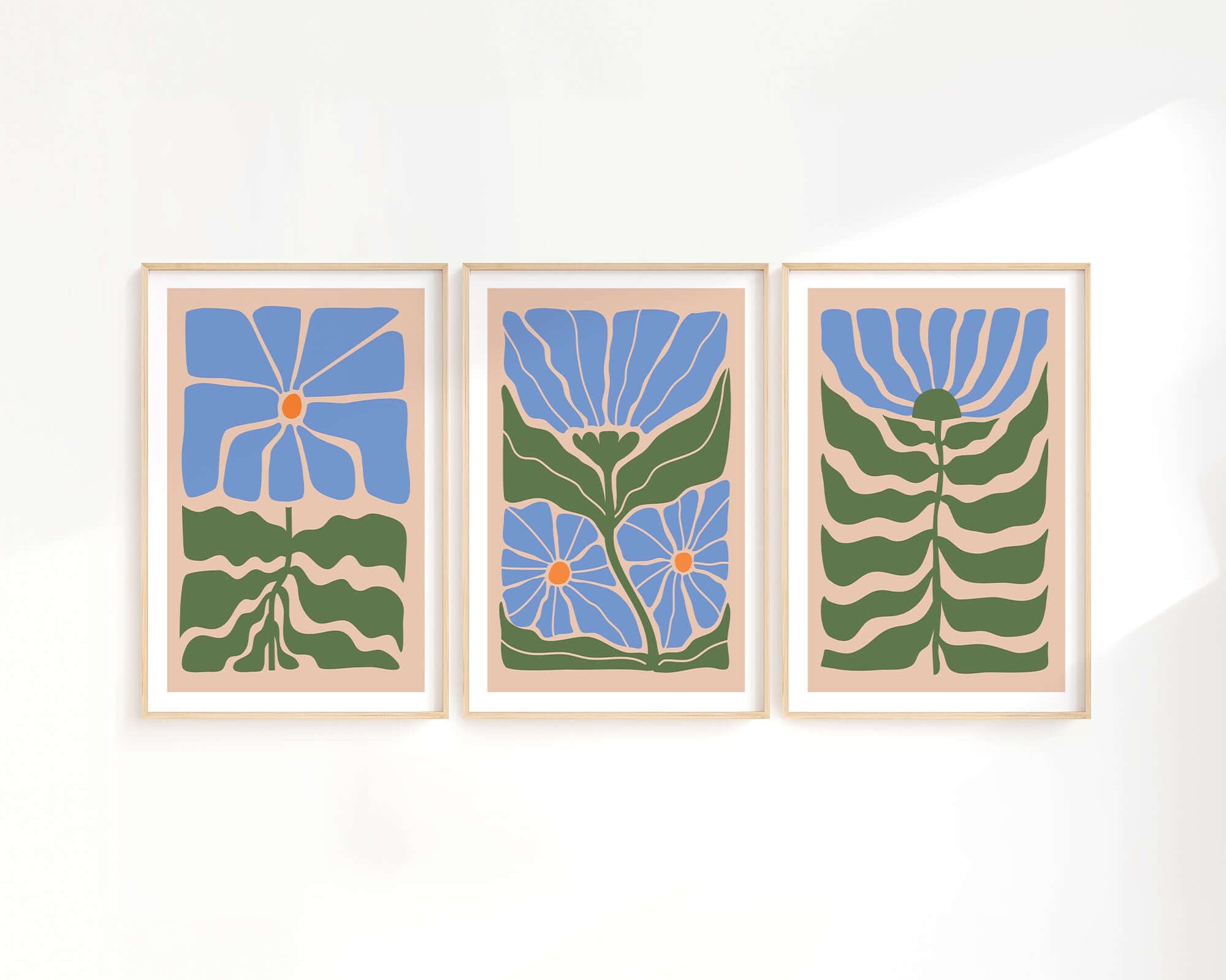 The Flower Blocks Triptych | Set of Three Prints | 009 showcases framed abstract floral art with blue flowers and green stems, ideal for enhancing home decor and looking stunning against a white wall.