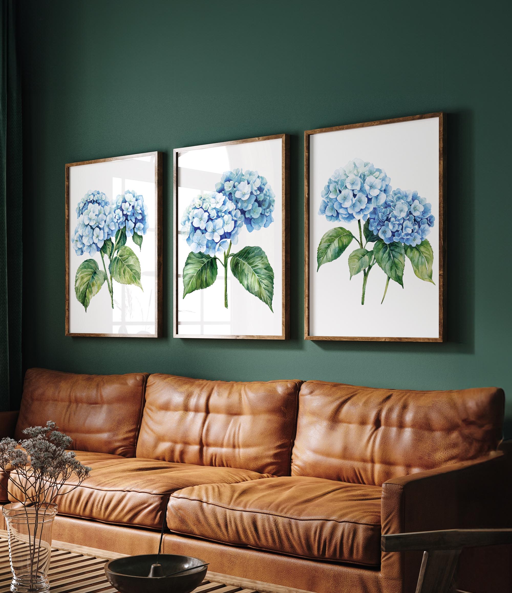 a cozy living room with a brown leather couch and a wooden coffee table. Above the couch, there are three framed watercolor paintings of blue hydrangeas hanging on the wall.