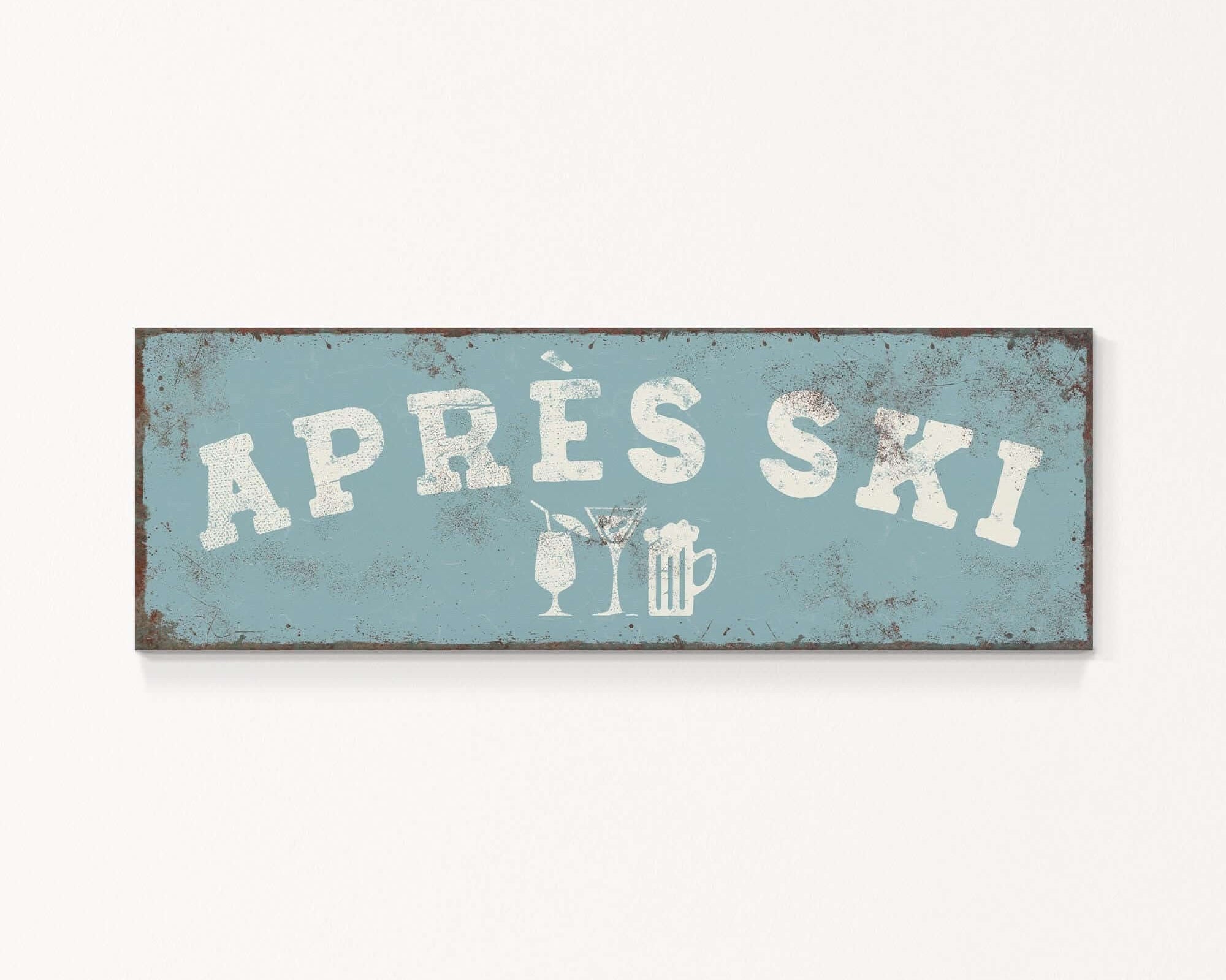 A weathered sign with the text "APRÈS SKI" in white letters, along with icons representing a beer and a martini glass.