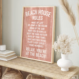 A Beach House Rules Sign, Painted Wood in Coral, sits framed on a woven console, adding charming coastal decor to the room.