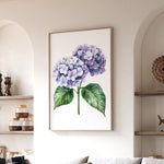 a framed painting of a purple hydrangea flower hanging on a wall in a living room.