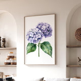 a framed painting of a purple hydrangea flower hanging on a wall in a living room.