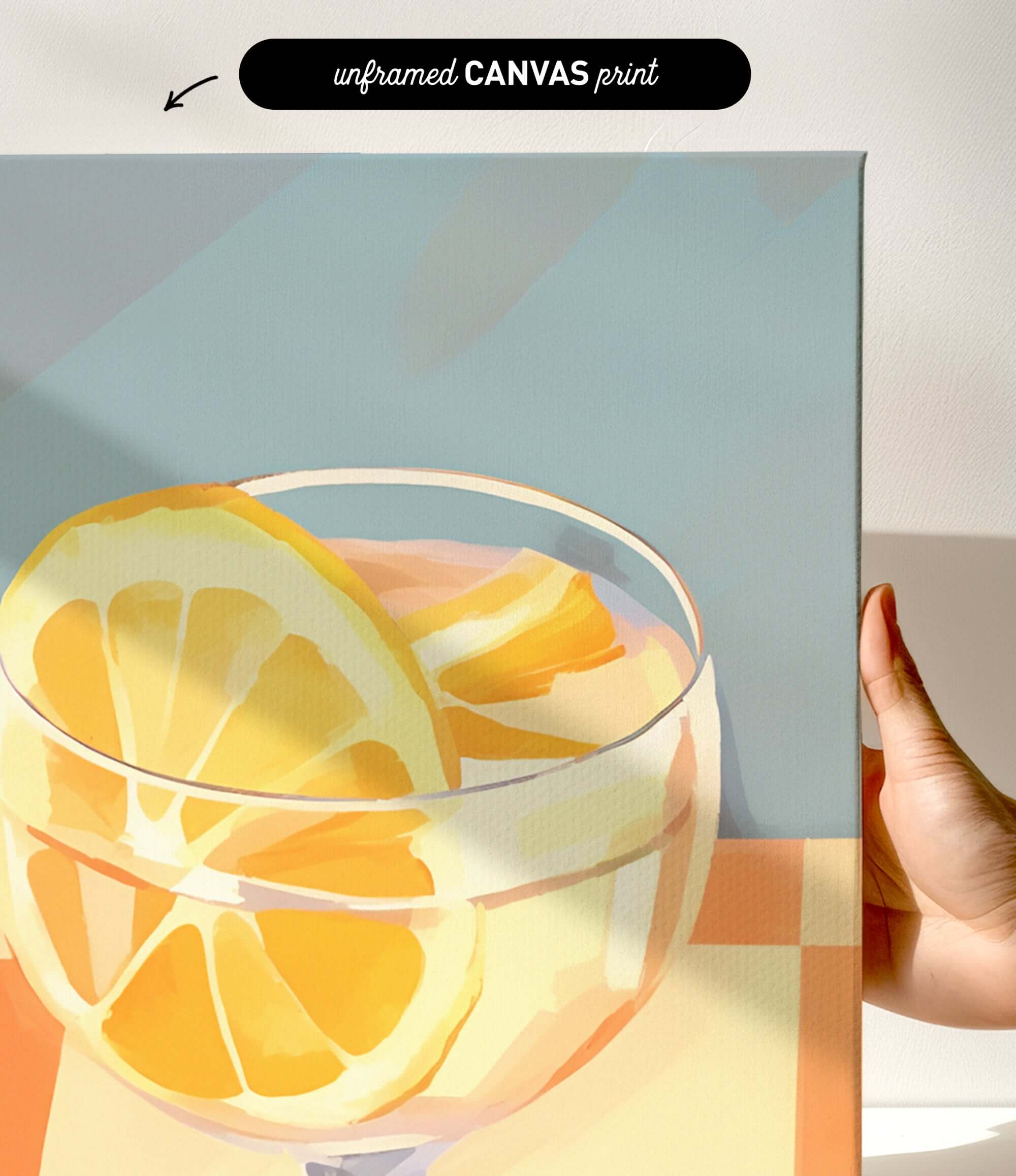 a close-up of a glass containing a slice of orange, with a hand holding the canvas.
