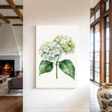 a large white canvas hanging on a wall, depicting a watercolor painting of a hydrangea flower with green leaves.