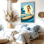 a bedroom with a large bed, a potted plant, and a framed illustration of a woman paddleboarding on a blue ocean.