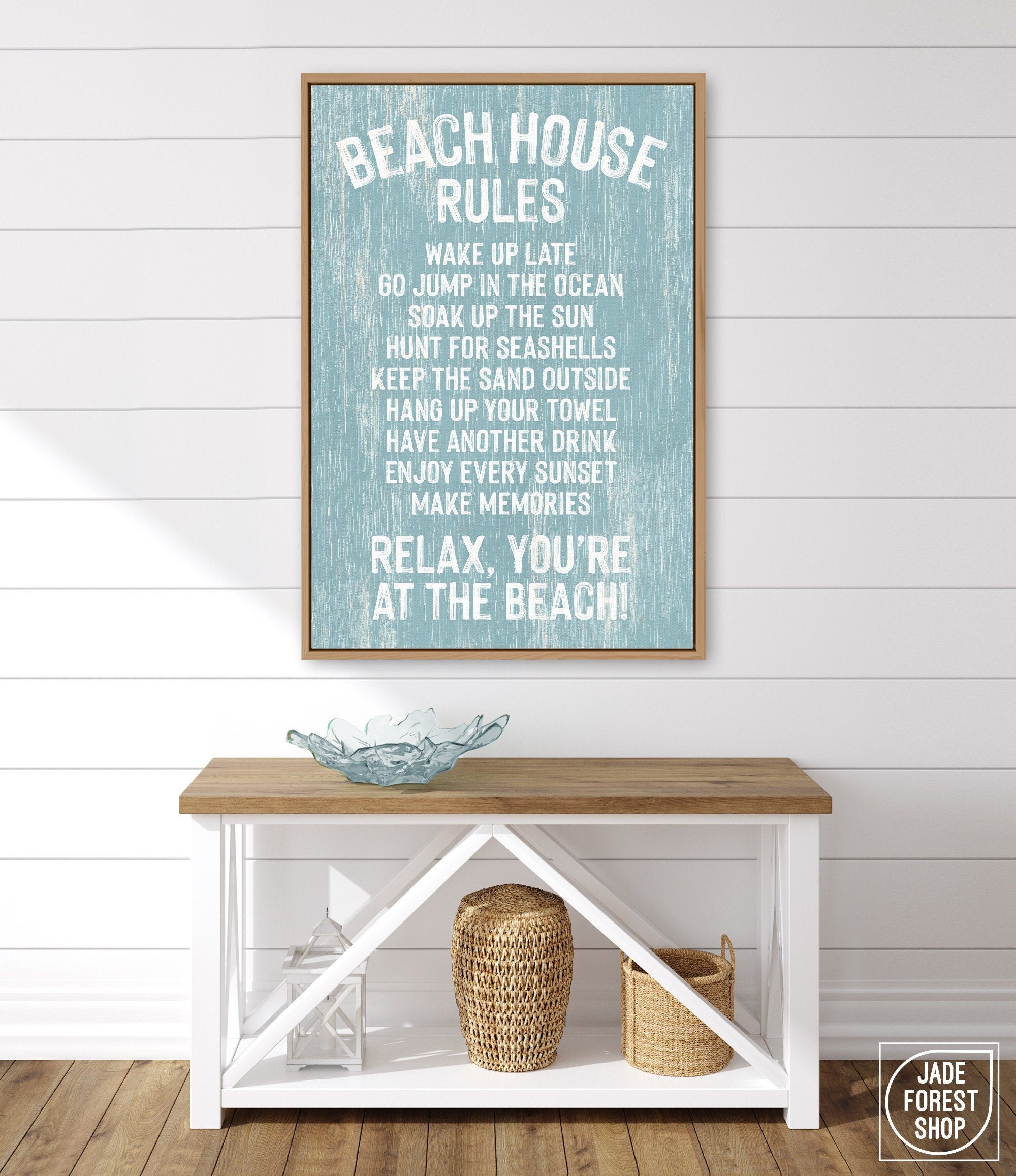 A Beach House Rules Sign in painted wood, in the Tide color, hangs above a wooden console table with decorative items and baskets, creating charming beach house wall decor.