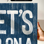 a person holding up a sign that says et&#39;s on a blue background