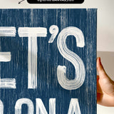 a person holding up a sign that says et&#39;s on a blue background