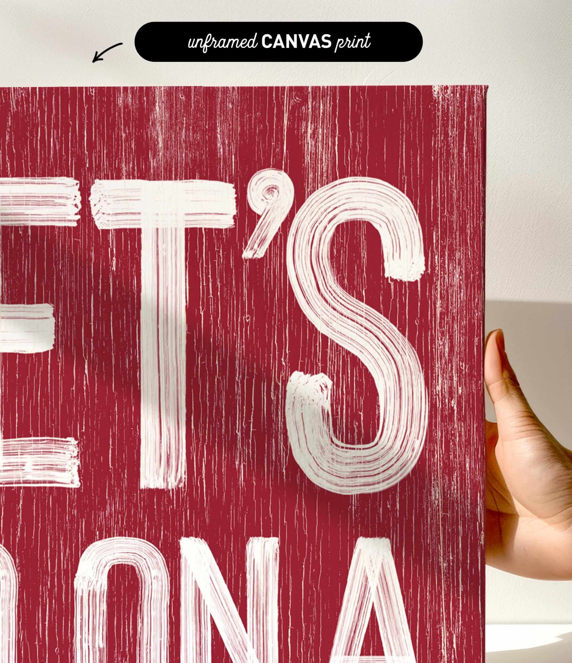 a hand holding a red poster with white lettering