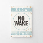 a sign that says slow no wake down