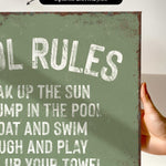a hand holding a sign that says pool rules