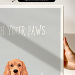 a hand holding a canvas print of a dog's head with the text "Witch Your Paws" written below it.