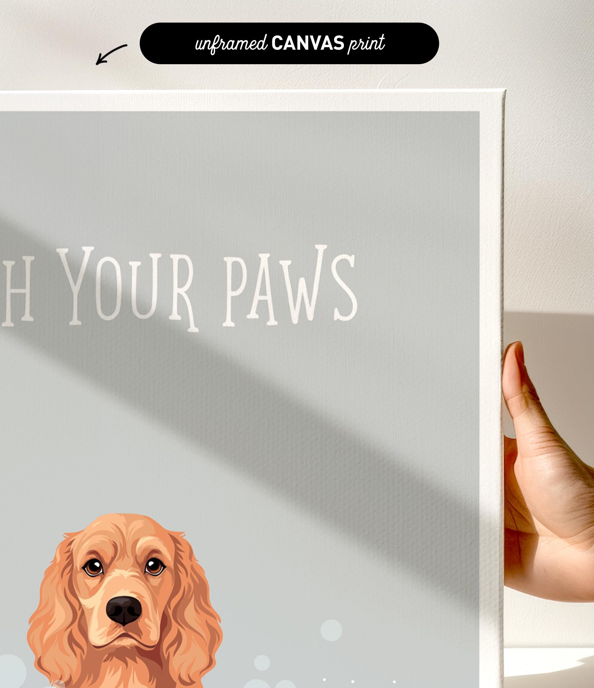 a hand holding a canvas print of a dog's head with the text "Witch Your Paws" written below it.