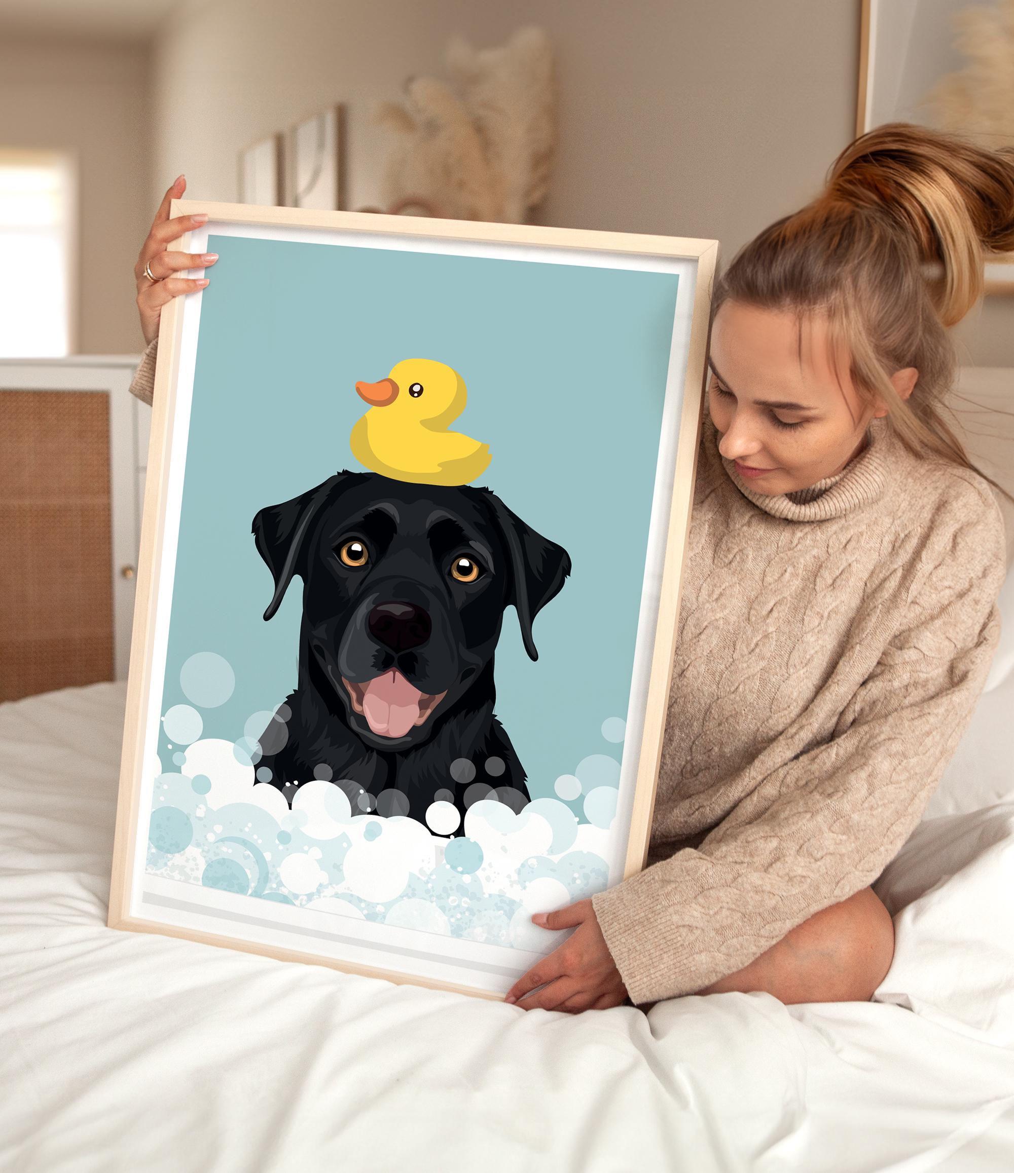 A woman is holding a framed picture of a black dog with a yellow rubber duck on its head, sitting on a bed.