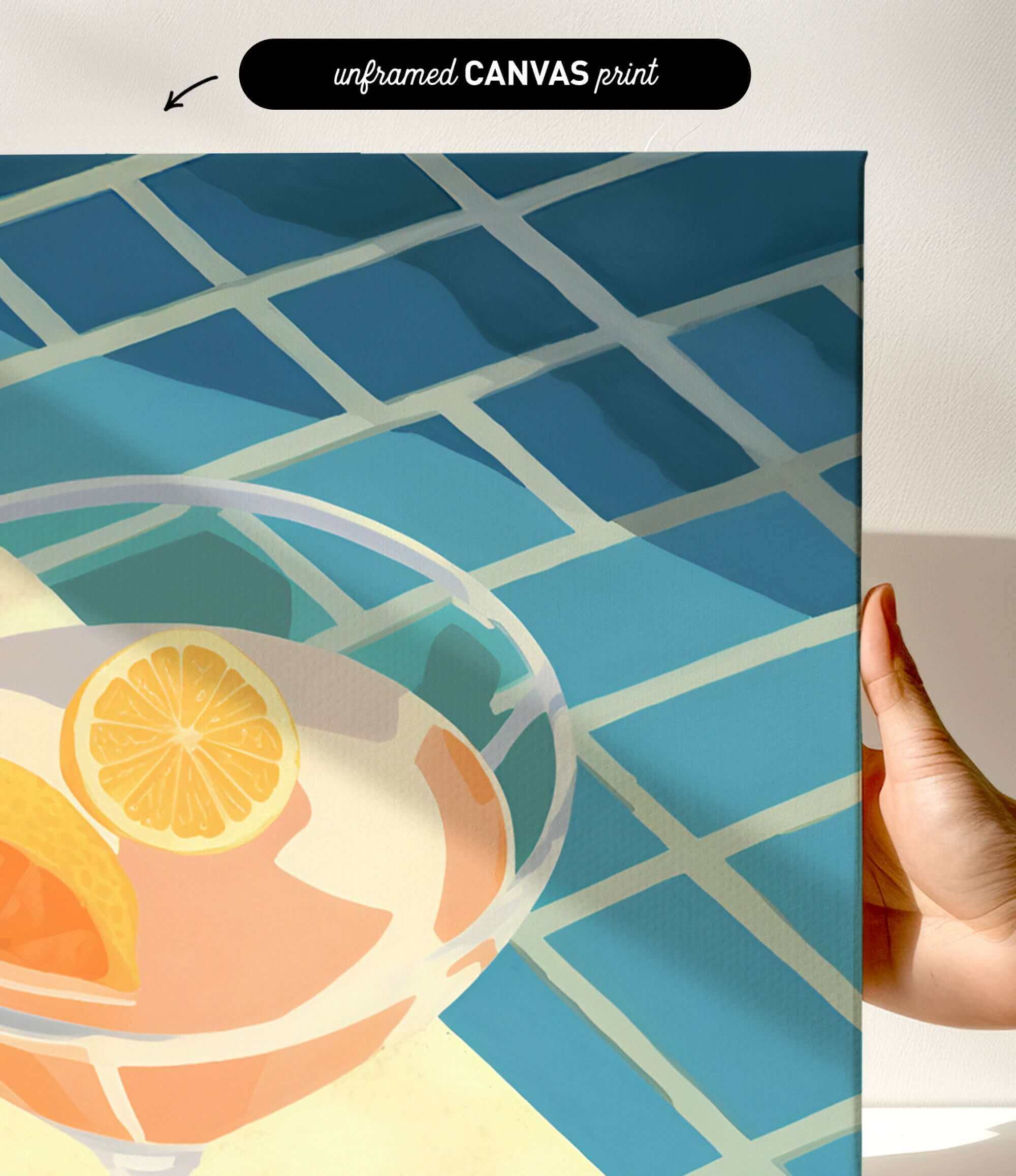 a hand holding a framed print of a colorful abstract design with a glass containing orange slices.