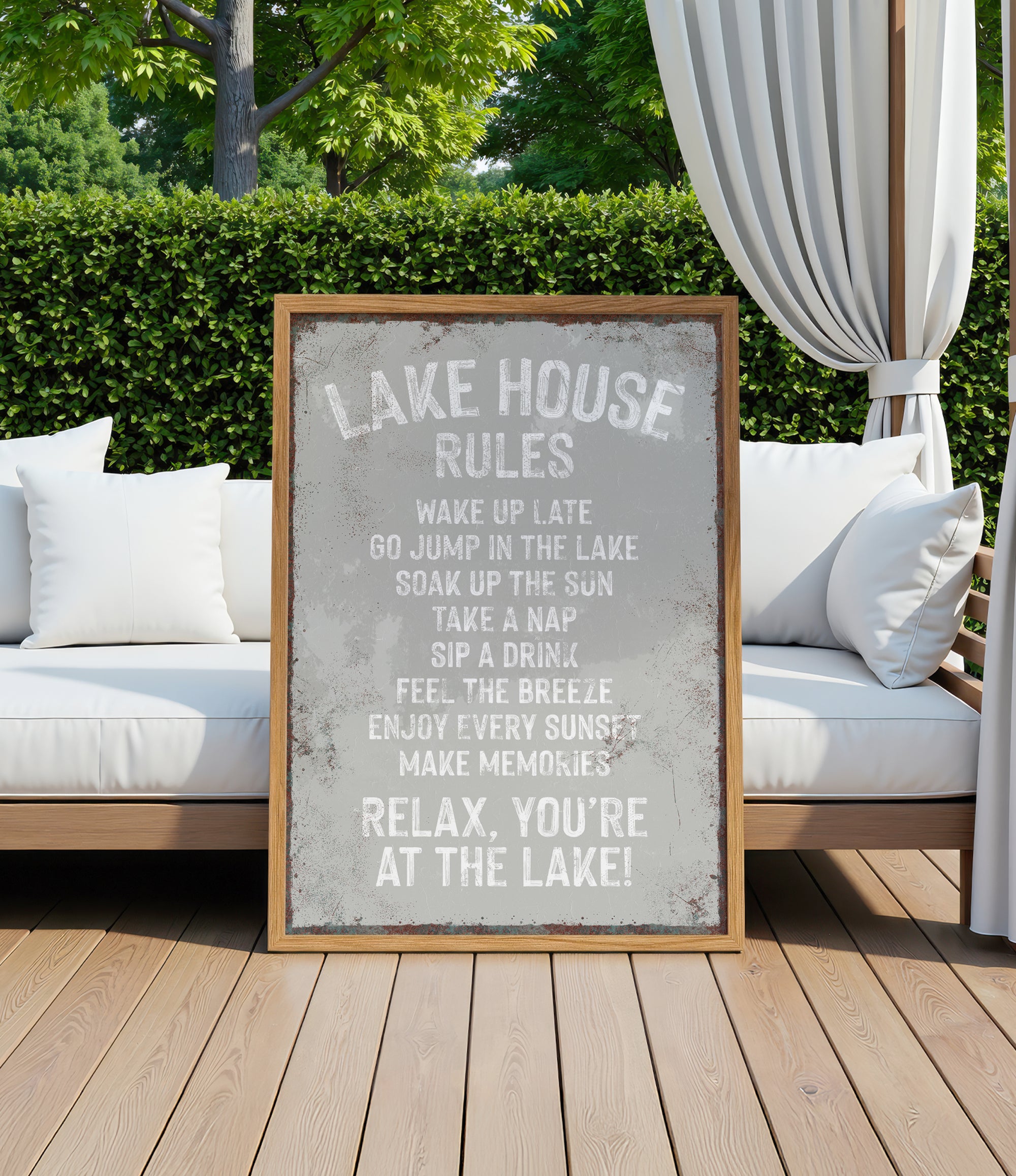 a sign that reads "LAKESHOUSE RULES" in a rustic wooden frame, placed on a wooden deck with a white couch and a white curtain in the background.