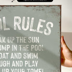 a hand holding a sign that says pool rules