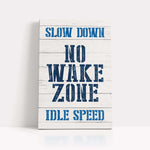a wooden sign that says slow down no wake zone
