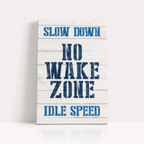 a wooden sign that says slow down no wake zone