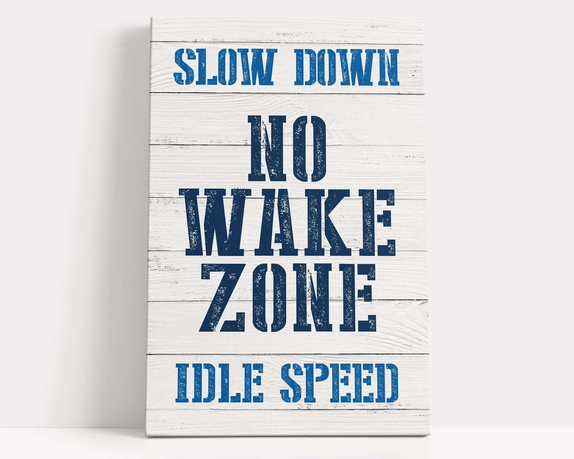 a wooden sign that says slow down no wake zone