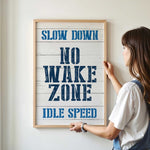 a woman holding a sign that reads slow down no wake zone idle speed