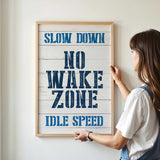 a woman holding a sign that reads slow down no wake zone idle speed