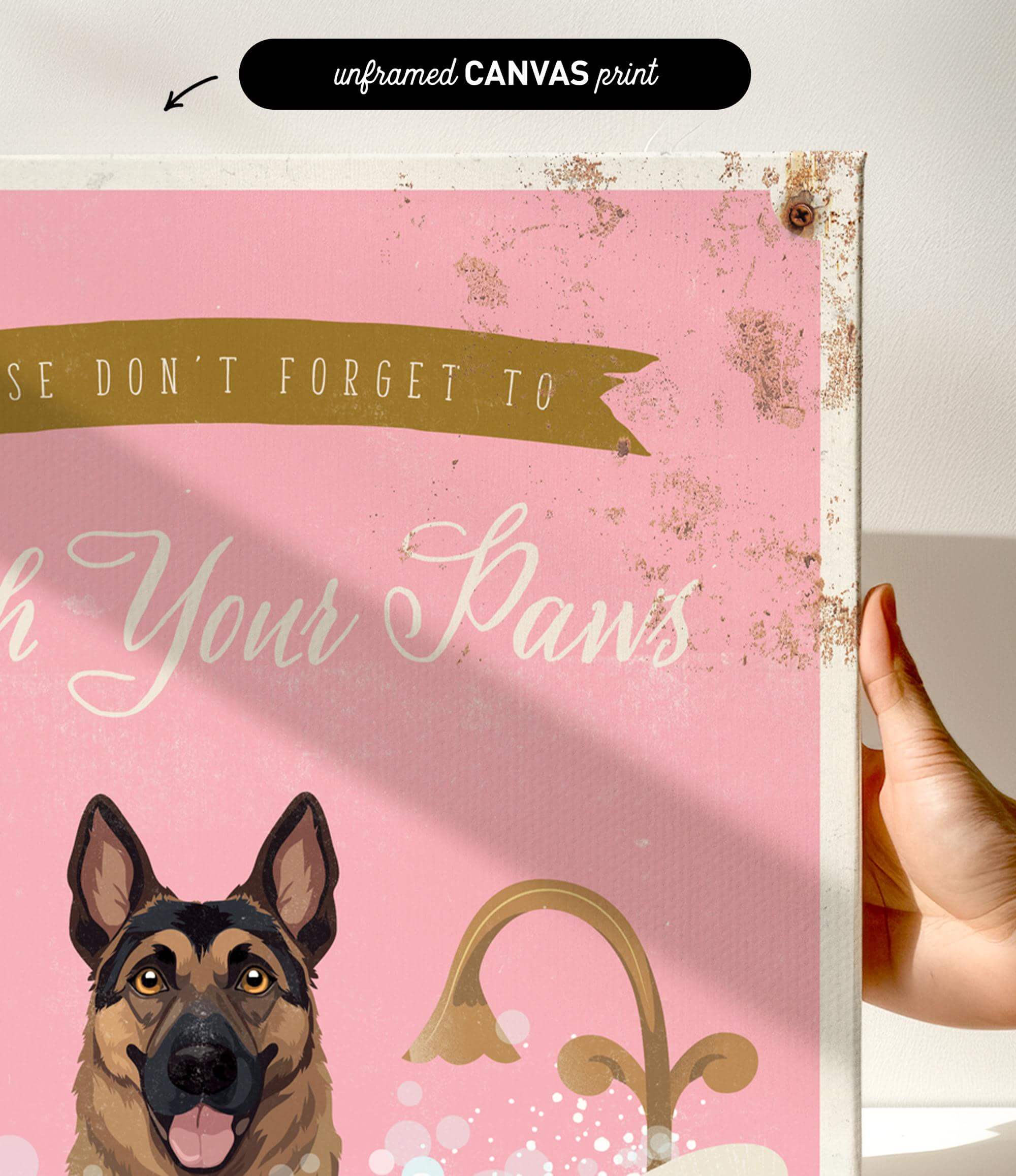 a hand holding a framed canvas print with a dog illustration and text.