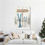A cozy living room featuring a white sofa, festive holiday decor, and the Cerulean Après Ski Signpost Wall Art above the couch—perfect for mountain lodge style.