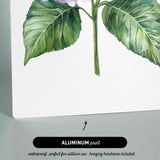 The image is an aluminum print featuring a watercolor painting of a flower with green leaves.