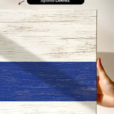 a hand holding a piece of wood with a blue strip painted on it