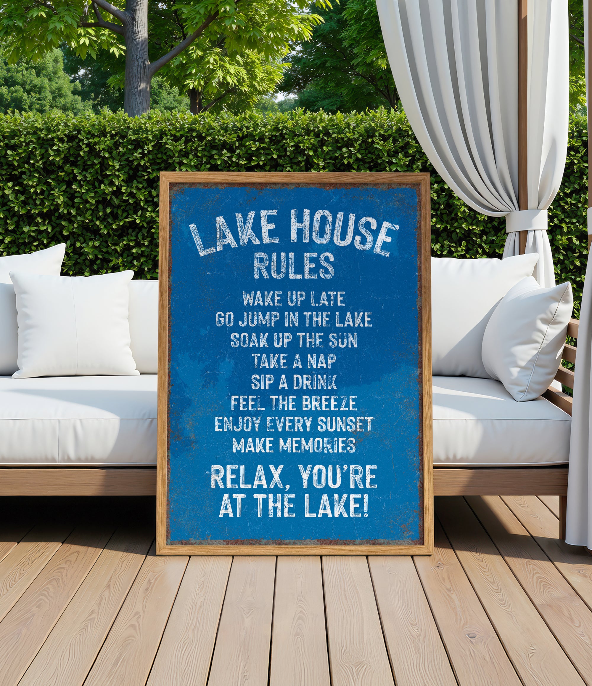A blue sign with white text is displayed in front of a wooden deck with white cushions, and a white curtain is visible in the background.