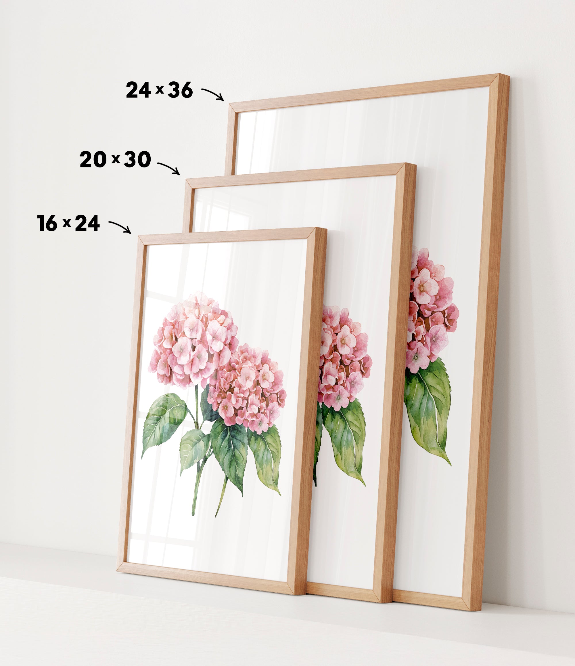 three framed prints of a watercolor painting of pink hydrangeas, each with a different size and frame.